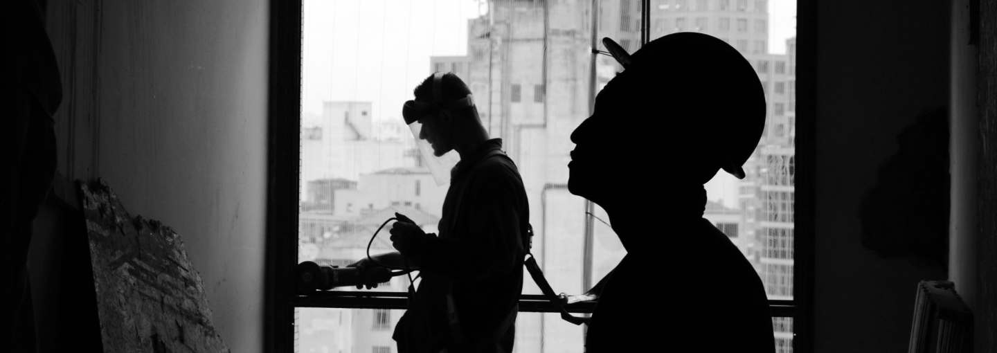 Oloid workers in silhouette against city background